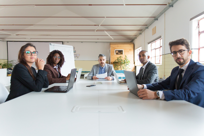 Group of serious managers during morning briefing
